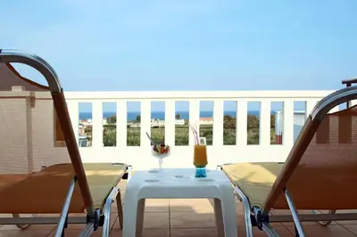 a table and chairs with a candle on a balcony at Kouros Chania Villas in Maleme