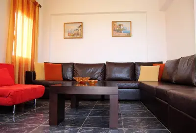 a living room with a leather couch and a coffee table at Kouros Chania Villas in Maleme