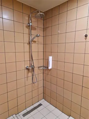 a shower in a bathroom with a tiled wall at Mosaic Apartments in Chania Town