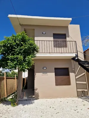 a house with a tree in front of it at Mosaic Apartments in Chania Town