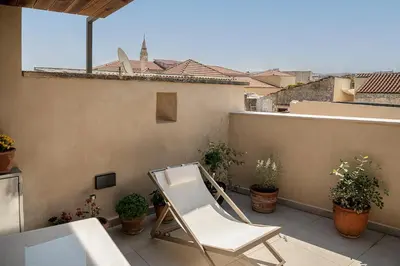 a white chair sitting on a balcony with plants at Austrinus house, luxury property for max. 5 persons in Chania Town