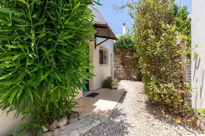 a garden entrance to a house with large green plants at Villa Henry Darmarohori in Darmarochori