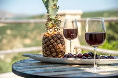 a pineapple and grapes on a table with wine glasses at Pool Villa Michail, in Kissamos! in Koukounará