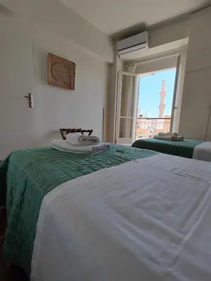 a bedroom with two beds and a window with a view at Chania-Limani Splantzia-geada in Chania Town
