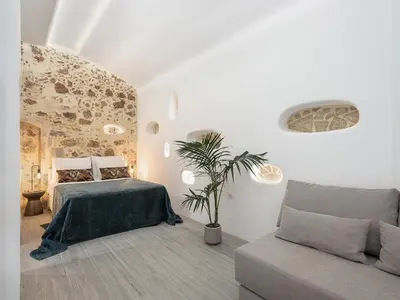 a bedroom with a bed and a couch at Malmáki, a street view apartment in Chania Town