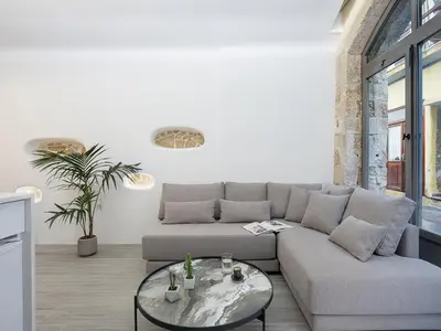 a living room with a couch and a table at Malmáki, a street view apartment in Chania Town
