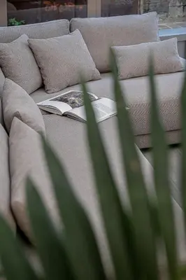 a book sitting on top of a couch with pillows at Malmáki, a street view apartment in Chania Town