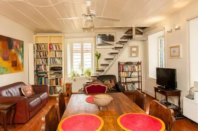 a living room with a table and a couch and a staircase at History & Culture in Old Town Chania in Chania Town