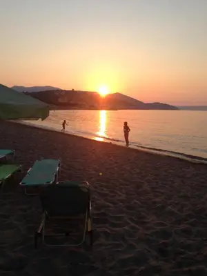 a person standing on a beach at sunset at Asterias Studios & Apartments in Kalyves