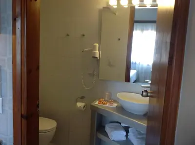 a bathroom with a sink and a toilet and a mirror at Asterias Studios & Apartments in Kalyves