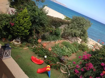 an aerial view of a garden with flowers and the ocean at Asterias Studios & Apartments in Kalyves