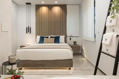 a bedroom with a large bed with blue pillows at Pi Suite Project Smart Living in Chania Town