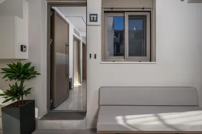 a white hallway with a bench and a window at Pi Suite Project Smart Living in Chania Town