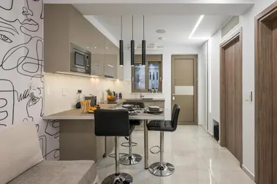 a kitchen with a table and black chairs at Pi Suite Project Smart Living in Chania Town