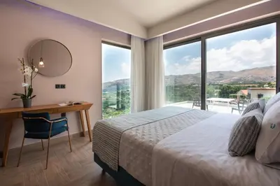 a bedroom with a bed and a desk with a mirror at Villas Libra in Falasarna