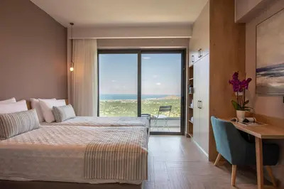 a hotel room with two beds and a view of the ocean at Villas Libra in Falasarna