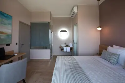 a bedroom with a bed and a desk and a sink at Villas Libra in Falasarna