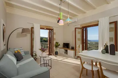 a living room with a blue couch and a table and chairs at Villas Libra in Falasarna