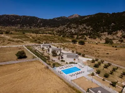 an aerial view of a house with a swimming pool at Omalos Village in Omalós