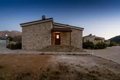 a small stone building with a door in a yard at Omalos Village in Omalós