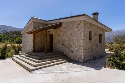 a small stone house with steps leading to a door at Omalos Village in Omalós