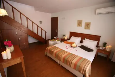 a bedroom with a large bed and a staircase at Flamingos Hotel Apartments in Kato Daratso