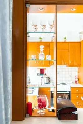 a glass cabinet with wine glasses in a kitchen at Peggy's apartment in Chania in Chania Town