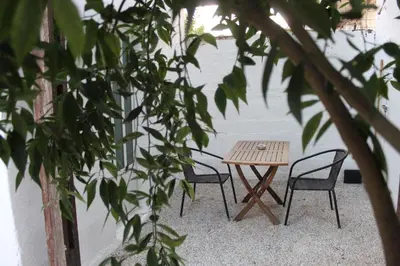 a wooden table and chairs sitting next to a wall at Peggy's apartment in Chania in Chania Town