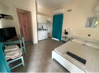 a bedroom with a bed and a desk and a television at Tersanas Beach Apartments in Chorafakia