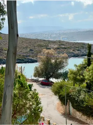 a red car parked in a parking lot next to a lake at Tersanas Beach Apartments in Chorafakia