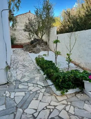 a garden with plants on a stone walkway at Tersanas Beach Apartments in Chorafakia