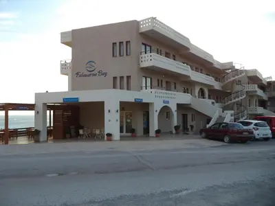 a large building with cars parked in front of it at Falasarna Bay in Falasarna