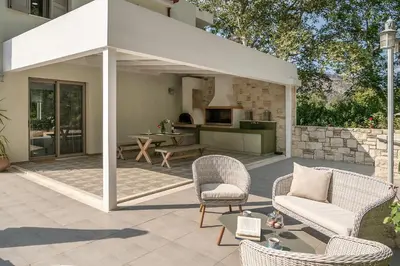 a pavilion with chairs and a table and a kitchen at Villa Nature, Heated Pool in Kalyves