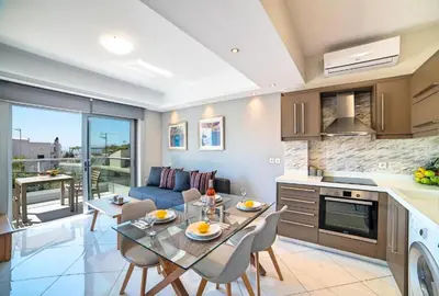 a kitchen and living room with a table and chairs at Sunshine Suite Family in Chania Town