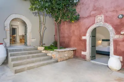 an entrance to a house with stairs and trees at Tholos Cottage in Stérnai