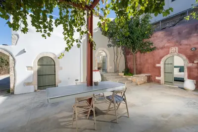 a table and two chairs in a courtyard at Tholos Cottage in Stérnai