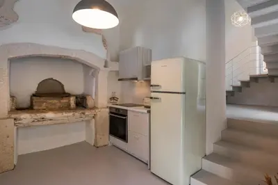 a kitchen with a refrigerator and a stove top oven at Tholos Cottage in Stérnai