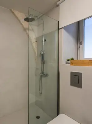 a shower with a glass door in a bathroom at Tholos Cottage in Stérnai
