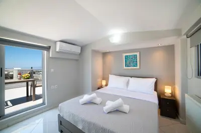 a bedroom with a large bed and a large window at Sunshine Suite Junior in Chania Town