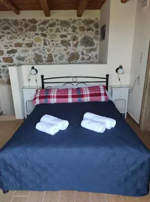 a bedroom with a blue bed with two white towels at Castello casa in Perivólia