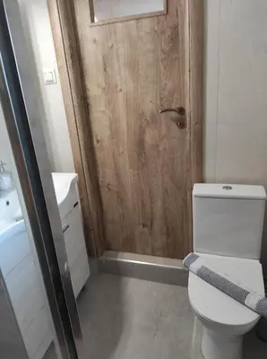 a bathroom with a toilet and a wooden door at Castello casa in Perivólia