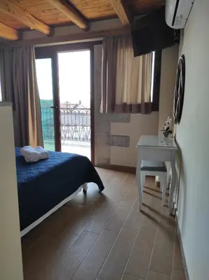 a bedroom with a bed and a table and a window at Castello casa in Perivólia