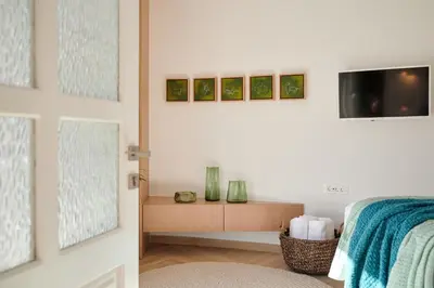 a bedroom with a bed and a tv on a wall at KaiZen Chania - New Central Apartment Just 350m Away With Private Jacuzzi and free parking! in Chania Town