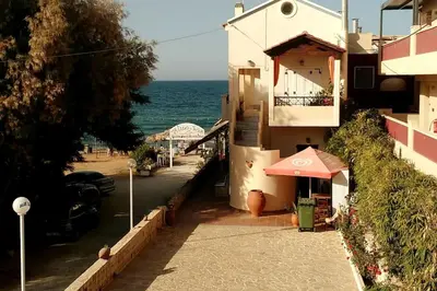 a building with an umbrella next to the ocean at 'Sky and Sea 1' Apartment in Kato Daratso