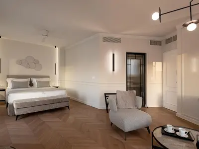 a bedroom with a bed and a chair at Riviera Suites in Chania Town