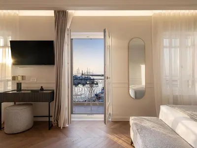 a bedroom with a bed and a desk and a window at Riviera Suites in Chania Town