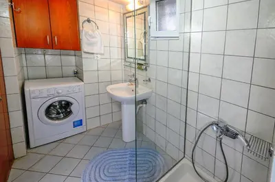 a bathroom with a sink and a washing machine at Popi's House in Chania Town