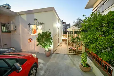 a red car parked in front of a house with plants at Popi's House in Chania Town