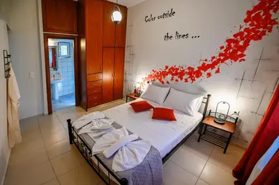 a bedroom with a bed with red flowers on the wall at Popi's House in Chania Town