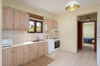 a kitchen with wooden cabinets and a sink and a stove at Villa Stratianna by PosarelliVillas in Módhion